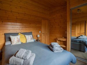 金罗斯Chalet Loch Leven Lodge 10 by Interhome的小木屋内一间卧室,配有一张床