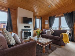 金罗斯Chalet Loch Leven Lodge 10 by Interhome的客厅设有两张沙发和一个壁炉