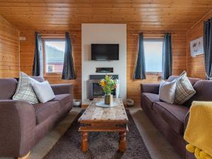 金罗斯Chalet Loch Leven Lodge 10 by Interhome的带沙发和咖啡桌的客厅