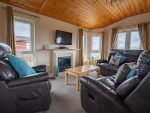 金罗斯Chalet Loch Leven Lodge 4 by Interhome的客厅配有皮革家具和壁炉