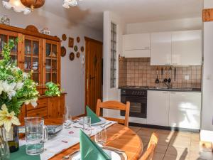 艾罗洛Apartment Rüthanet by Interhome的厨房以及带木桌的用餐室。