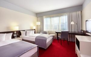 舍讷费尔德柏林机场-会议中心假日酒店的酒店客房配有两张床和一张书桌