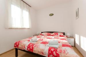 苏佩塔尔House Bojan的一间卧室配有一张带红色和白色棉被的床