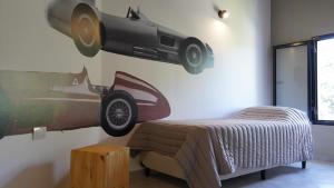里奥塞瓦约斯Eos Sporthaus的卧室配有一张床铺,墙上挂有汽车