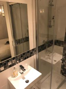 伊斯特布恩亚特兰大旅馆的带淋浴、盥洗盆和镜子的浴室