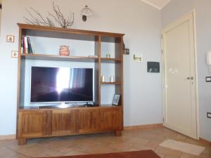 内比达Casa Margherita的客厅设有电视,位于木制娱乐中心