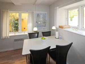 古兹耶姆Apartment Amaia - 500m from the sea in Bornholm by Interhome的一间配备有白色桌椅的用餐室