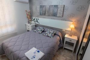 卡斯特利翁-德拉普拉纳La Mirada 2的一间卧室配有床、两张桌子和一盏灯。