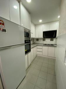普特拉贾亚D'PUDINA的白色的厨房配有白色橱柜和电器