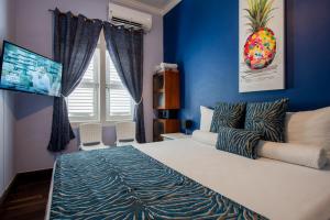 威廉斯塔德Villa Amalie & Villa Curiel的一间卧室配有一张带蓝色墙壁的大床