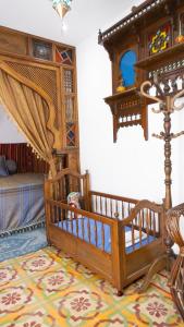 苏塞Dar El Goulli的一间卧室配有一张婴儿床和一张位于客房内的床。