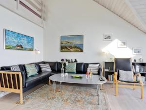 海斯勒Holiday Home Momo - 10m from the sea in Bornholm by Interhome的客厅配有黑色沙发和桌子