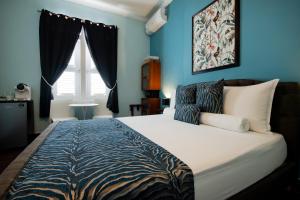 威廉斯塔德Villa Amalie & Villa Curiel的一间卧室配有一张带蓝色墙壁的大床