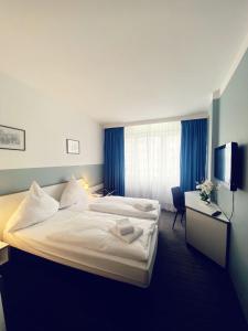 美因河畔法兰克福Hotel City Kräme am Römer - Self Check In的酒店客房设有两张床和电视。