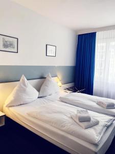 美因河畔法兰克福Hotel City Kräme am Römer - Self Check In的一间卧室设有两张带蓝色墙壁和窗户的床。