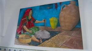 苏塞Dar El Goulli的花瓶旁地板上坐着的女人的画