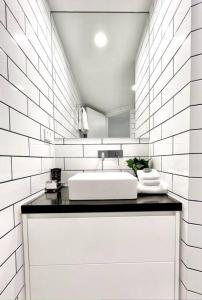 努萨角225 2 Bedroom Garden Oasis French Quarter Resort的白色的浴室设有水槽和镜子