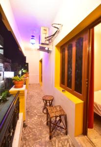 蓬蒂切里Villa Felicia的一间设有两张凳子的房间和一间带黄色和白色墙壁的房间