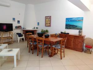 圣维托罗卡波SanvitoTour - Le Terrazze的一间带木桌和椅子的用餐室