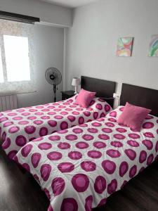 拉斯纳瓦斯德尔马尔克斯Tres Cruces Apartment的卧室配有一张带粉红色枕头的大床