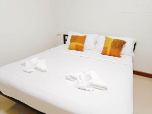 尖竹汶Baan PhakDeeChan的一张白色的床,上面有枕头