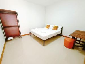 尖竹汶Baan PhakDeeChan的白色的客房配有一张床和一张桌子