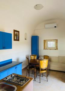 托雷德尔格雷科克拉丽娜乡村民宿的厨房配有蓝色橱柜和桌椅