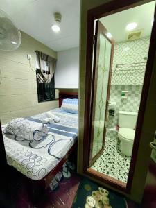 香港京都旅馆	的一间带一张床的卧室和一间带镜子的浴室