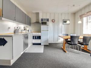 HavnebyApartment Alfkil - 2-3km from the sea in Western Jutland by Interhome的厨房配有白色家电和木桌