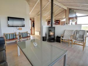 拉科克Holiday Home Alim - 300m from the sea in Western Jutland by Interhome的客厅设有玻璃桌和壁炉