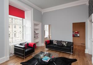 爱丁堡Parliament Sq apt 12 Royal Mile的客厅配有黑色沙发和桌子