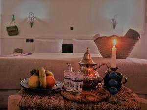 布马伦Riad Bleu Afriqua的一张桌子,上面放着一盘水果和一支蜡烛
