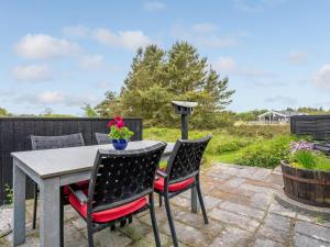 博利尔马克Holiday Home Kathaline - 3-4km from the sea in Western Jutland by Interhome的庭院配有桌子和四把椅子