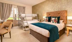 卡斯尔巴布拉菲酒店加Spa的一间卧室配有两张床、一张桌子和一把椅子