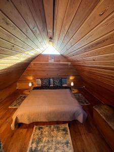 奥格雷Pirtiņa的木制客房内的一间卧室,配有一张床