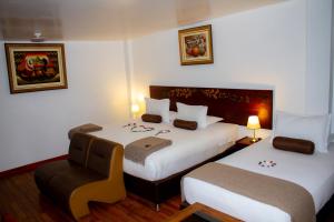 马丘比丘Hotel Retama Machupicchu的酒店客房,配有两张床和椅子
