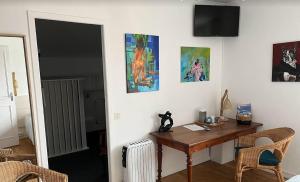 安格雷Haritza的客房设有书桌,墙上挂有一些绘画作品