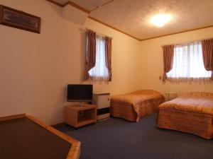 白马村彩虹山林小屋的酒店客房设有两张床和一台平面电视。