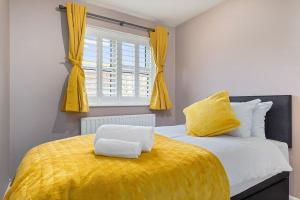 奥平顿Flourish Apartments - Footbury House - Orpington的一间卧室配有一张带黄色毯子和窗户的床