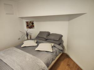 Pardes H̱annaהמקום של מוש的卧室配有一张带灰色床单和枕头的床。