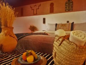 布马伦Riad Bleu Afriqua的一间设有一张床和一张桌子及一盘水果的房间