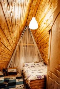 阿尔杰什河畔库尔泰亚CabanaAframe intreaga proprietate的木制帐篷内一间卧室(带一张床)