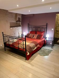 武夫赖Troglodyte du Petit Coteau的一间卧室配有一张带红色枕头的大床