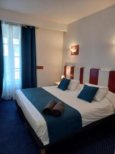 莱塞比耶勒中心酒店的酒店客房配有一张带蓝色枕头的大床