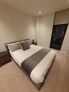 曼彻斯特Lovely 2Bedroom Apartment的卧室内的一张大床,设有窗户