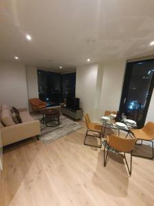 曼彻斯特Lovely 2Bedroom Apartment的客厅配有沙发和桌椅