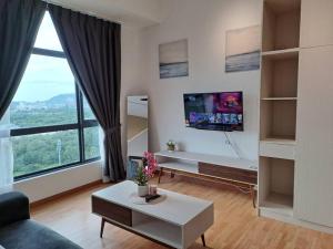 关丹Best Moments Studio City - Imperium Residence的客厅配有沙发和墙上的电视