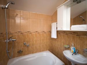 卡梅纳里阳光山度假屋的带淋浴、盥洗盆和浴缸的浴室