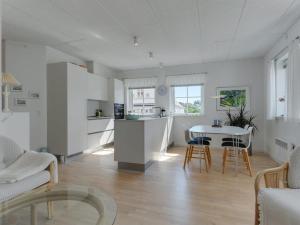 约灵Apartment Cornel - 400m from the sea in NW Jutland by Interhome的厨房以及带桌椅的起居室。