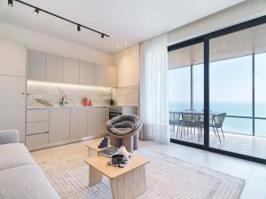 拉纳卡LIV Mackenzie Beach Suites Larnaca ADULTS ONLY的客厅配有沙发和桌子